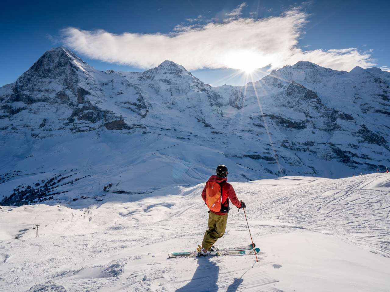 Skiing in the Grindelwald - Wengen ski area. Skiers take a break and enjoy the panoramic view of the Eiger, Mönch and Jungfrau triumvirate.